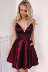 Robe de bal courte bordeaux en satin, coupe trapèze, col en V et poches