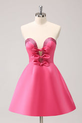 Robe de bal rose fuchsia ravissante, coupe trapèze, sans bretelles, découpée et ornée de perles