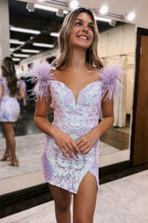 Vestido corto morado de fiesta, estilo tubo, con hombros descubiertos y detalles de plumas.
