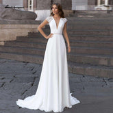 Vestido de novia Abiti Donna Modest Bridal corte A, verano 2025. Sencillo, con escote en V, espalda descubierta, ideal para bodas en la playa. Cola larga.