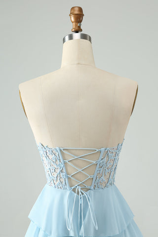Robe de bal courte bleu clair à volants et décolleté en cœur, coupe trapèze, ornée d'appliqués