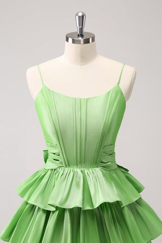 Robe de bal verte mignonne, coupe trapèze, bretelles spaghetti, corset à volants étagés et nœud.