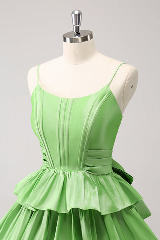 Robe de bal verte mignonne, coupe trapèze, bretelles spaghetti, corset à volants étagés et nœud.