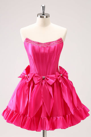 Robe de bal fuchsia mignonne, coupe trapèze, bustier, à volants, perles et nœuds