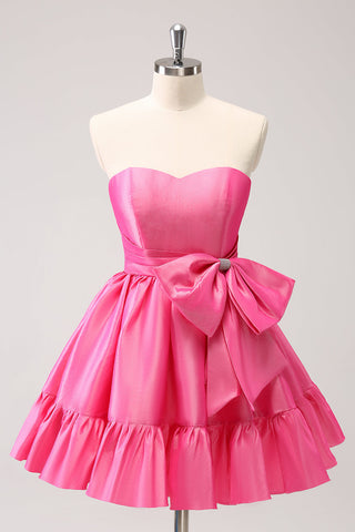Robe de bal courte plissée rose fuchsia, coupe trapèze, sans bretelles, avec nœud. Adorable robe de soirée courte plissée, sans bretelles, coupe trapèze.