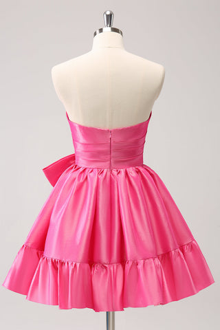 Robe de bal courte plissée rose fuchsia, coupe trapèze, sans bretelles, avec nœud. Adorable robe de soirée courte plissée, sans bretelles, coupe trapèze.