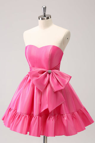 Robe de bal courte plissée rose fuchsia, coupe trapèze, sans bretelles, avec nœud. Adorable robe de soirée courte plissée, sans bretelles, coupe trapèze.