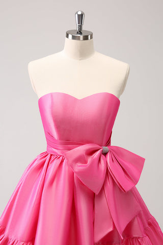 Robe de bal courte plissée rose fuchsia, coupe trapèze, sans bretelles, avec nœud. Adorable robe de soirée courte plissée, sans bretelles, coupe trapèze.
