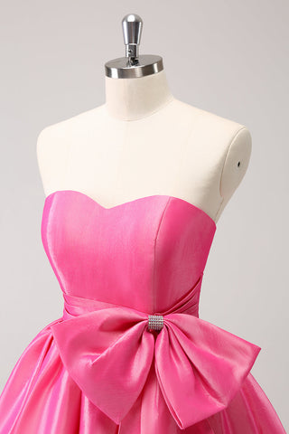 Robe de bal courte plissée rose fuchsia, coupe trapèze, sans bretelles, avec nœud. Adorable robe de soirée courte plissée, sans bretelles, coupe trapèze.