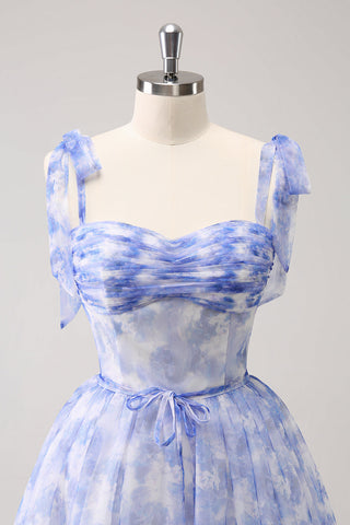 Robe de bal courte bleue à bretelles spaghetti, plissée et coupe trapèze, avec laçage au dos.