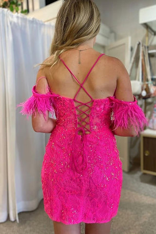 Precioso vestido corto fucsia de corte recto con hombros descubiertos y detalles de plumas.