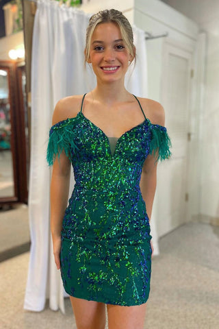 Vestido corto verde oscuro brillante de corte sirena con hombros descubiertos y detalles de plumas.