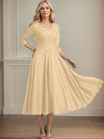 Vestido de corte A, escote en V, largo hasta la rodilla, de gasa, encaje, con lentejuelas y pedrería para la madre de la novia. 