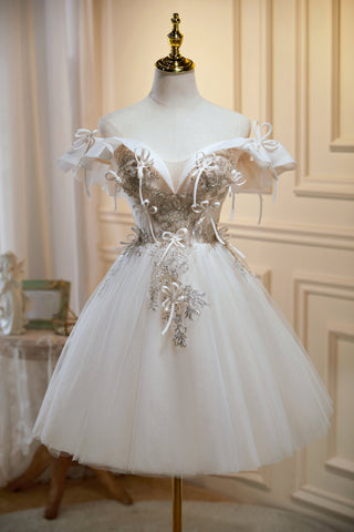 Vestidos cortos de tul con escote en V y hombros descubiertos, estilo chic, ideales para fiestas de bienvenida. 