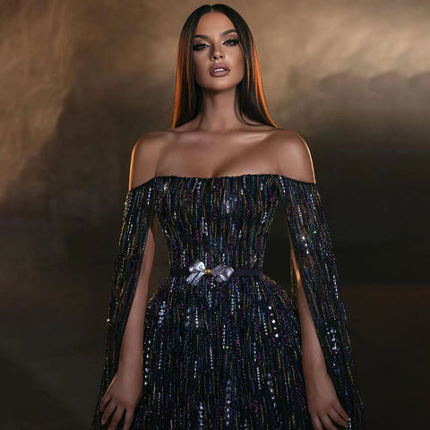 Vestido de noche negro de corte A, sexy, sin tirantes, con mangas tipo capa y adornado con cristales, ideal para fiestas. Modelo LA71824. 