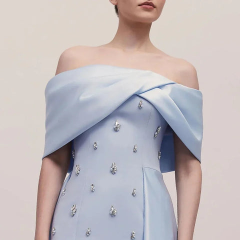 Vestido de noche azul satinado, sencillo y elegante, con escote barco y abertura alta tipo sirena, adornado con cuentas, ideal para fiestas y ocasiones especiales. Modelo LA72458 