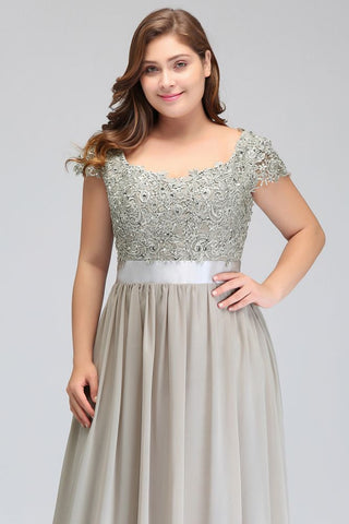 Robe de soirée argentée à manches courtes et décolleté trapèze, ornée d'appliques et d'une ceinture, longueur au sol.