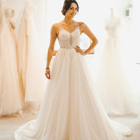 Robe de mariée sobre longue en tulle, coupe trapèze, bretelles spaghetti et dos nu, style A-line.