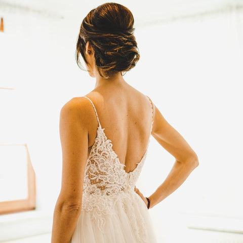 Robe de mariée sobre longue en tulle, coupe trapèze, bretelles spaghetti et dos nu, style A-line.