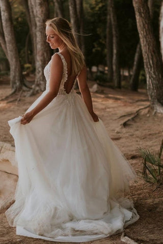 Robe de mariée en tulle longue sans manches, à bretelles discrètes et ornée d'appliqués 