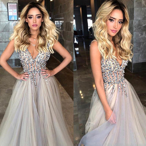 Robe de bal longue et sobre, grise, à col en V et ourlet trapèze, ornée de perles et d'une traîne. 